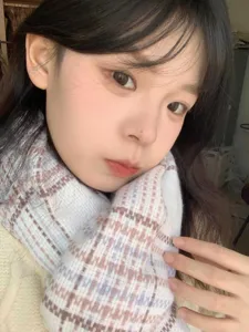 Gros plan détaillé du foulard d'hiver à carreaux doux montrant le tissu texturé et le design douillet.