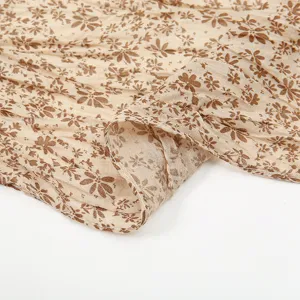 Close-up van de lichte beige gekreukte sjaal met een prachtige retro bruine bloemenprint.