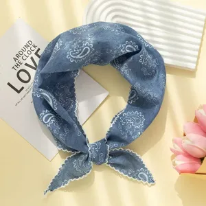 Gros plan sur le foulard triangulaire en coton lin bleu paisley avec bordure en dentelle.