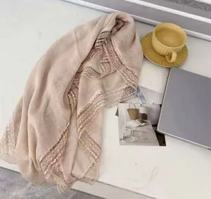 Elegantes, beige Schal-Detail mit Spitzensaum, weicher transparenter Stoff für Sommer-Styling.