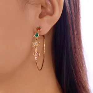 Close-up of Christmas hoop earrings with tree, snowflake, and candy cane details