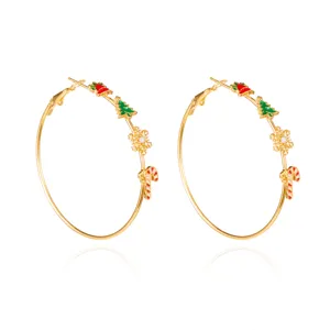 Detailed view of gold hoop earrings with festive Christmas tree and candy cane charms