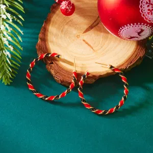 Christmas themed hoop earrings with red and black twisted pattern on a festive background