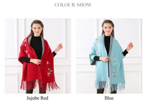 Detailansicht der roten und blauen bestickten Strickschals mit Ärmeln und Fransen.