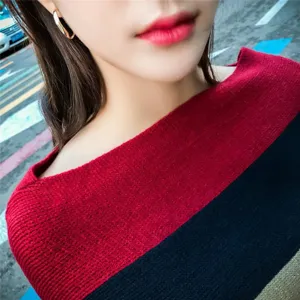 Macro detail of fashionable red and black striped knitted poncho shawl with soft texture