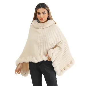 Front view of beige knit poncho featuring a plush faux fur collar and hem details