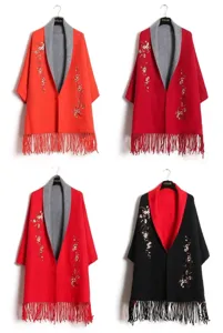 Strick-Ponchos in verschiedenen Farben mit zarter Blumenstickerei und langen Fransen