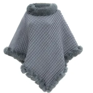 Detailed view of grey knitted poncho with soft faux fur collar and elegant waffle texture