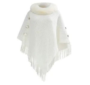 White knitted poncho with faux fur collar and tassels, elegant autumn winter pullover.