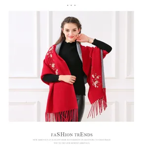 Eleganter roter Strickschal mit Pflaumenblütenstickerei und Fransen, getragen von einem Modell.
