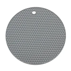 Detalle de almohadilla aislante de silicona en panal, estera de cocina redonda resistente.