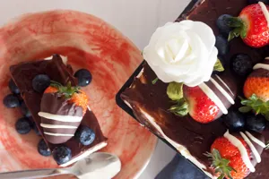 Delicious chocolate cake decorated with fresh strawberries and blueberries for dessert.