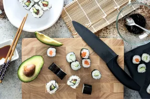 Japanese sushi making scene flat lay with wooden cutting board and sharp chef knife