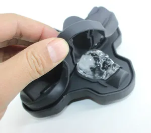 Detalle de primer plano de molde de cubitos de hielo de calavera 3D de silicona negra.