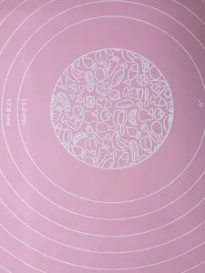Thick silicone baking mat with measurement scales and cute central food pattern design for baking.