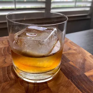 Klares quadratisches Eiswuerfel im Whiskyglas Detailbild zeigt grosses Eissilikonform.
