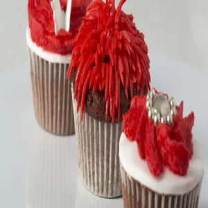 Delicious red decorative cupcakes with creative frosting for bakery display and party decor.