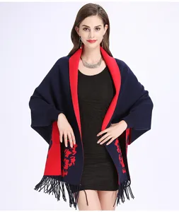 Detailansicht eines marineblau-roten Jacquard-Ponchos mit eleganten Blumenmustern und Fransen