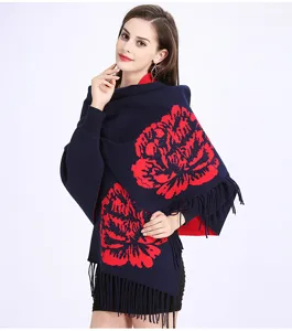 Detailansicht eines dunkelblauen Jacquard-Schal-Ponchos mit rotem Pfingstrosenmuster und Fransen