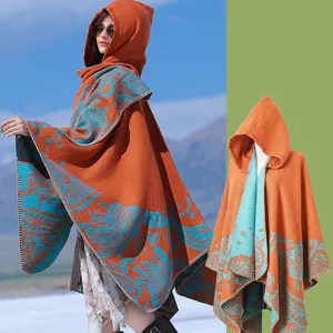 Detail of a knitted hooded poncho with intricate teal paisley patterns on orange fabric