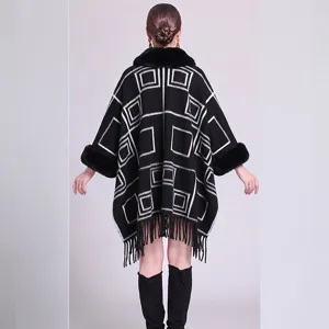 Rückansicht eines schwarzen Strickponchos mit geometrischem Muster und Kunstpelzkragen