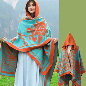 Detailansicht des gestrickten Kapuzenponchos mit orange-türkisen Ethno-Mustern.