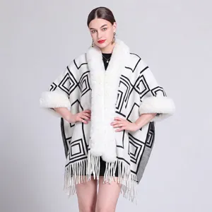 Detail des weißen Ponchos mit dickem Kunstpelzkragen und geometrischem Jacquard