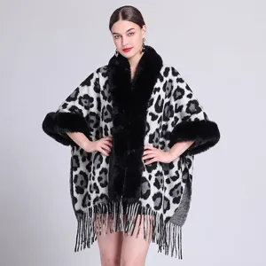 Detailansicht eines Strickponchos mit Leopardenmuster, Kunstpelzkragen und Fransen.