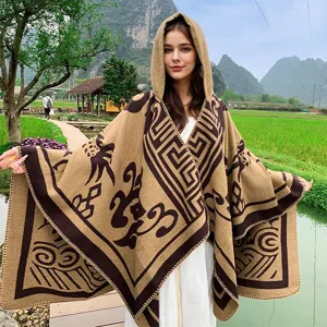 Model trägt einen braunen Kapuzen-Strickponcho mit Stammesmustern in der Natur