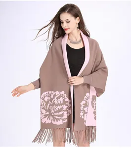 Detailaufnahme eines dicken Jacquard-Blumenschals mit Quasten und Ärmeln für den Winter