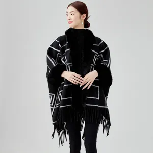 Eleganter schwarzer Strickponcho mit geometrischem Muster, Kunstfellkragen und Fransen.