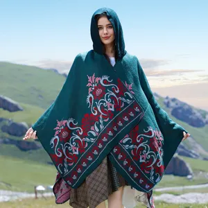 Close-up detail of a women's dark green hooded knit shawl with red floral patterns