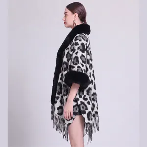 Detailansicht eines Strickschals mit Leopardenmuster, Kunstpelzkragen und Fransen.