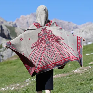 Rückansicht eines dicken Kapuzenponchos mit traditionellen Mustern in den Bergen