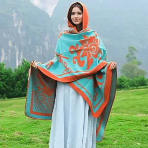 Detailansicht einer Frau im Freien mit einem blau-orangen Kapuzenstrickschal Poncho.