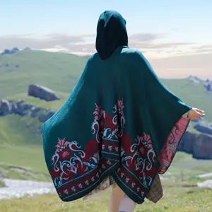 Back view of dark green hooded knitted poncho with red vintage floral jacquard pattern.