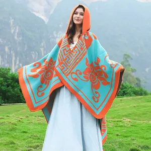 Model trägt einen türkisen und orangefarbenen Kapuzen-Strickumhang mit Ethno-Muster