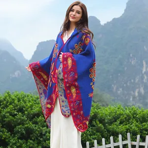 Eleganter blauer Paisley-Jacquard-Kapuzen-Poncho-Schal, von einem Modell im Gebirge getragen
