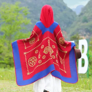Roter und blauer Strick-Kapuzenponcho mit Ethno-Muster, Rückansicht in natürlicher Umgebung