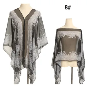 Detail des schwarzen Strandtuchs mit Paisley-Print und Perlenknöpfen