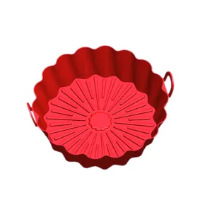 Detailed view of the red silicone air fryer pot with handles and raised bottom ribs for oil drainage.