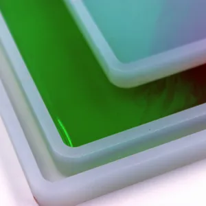 Primer plano detallado de moldes de silicona para resina y bandejas epoxi, bordes lisos y coloridos.