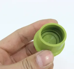 Close-up of green silicone wine bottle stopper showing internal anti-leak sealing rings.