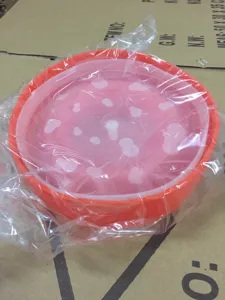 Detalle de bol de palomitas de silicona plegable, cubo microondas resistente con tapa y puntos.