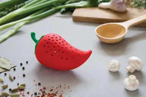 Silicone red pepper tea infuser detail shot on kitchen counter with herbs and spices