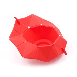 Primer plano de un bol de palomitas de silicona roja plegable con diseño geométrico.