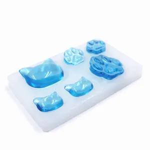 DIY cat paw and head silicone mold with blue resin pieces for handmade jewelry making.