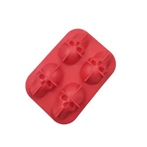 Top view of a red silicone mold showing four detailed 3D skull cavities for ice cubes.