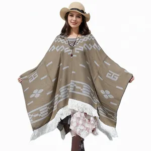 Vollansicht eines Strick-Ponchos mit geometrischen Mustern und weißen Fransen