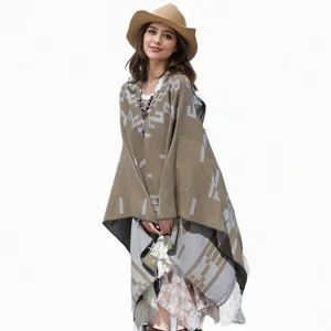 Detailansicht eines schicken Strick-Ponchos mit geometrischen Mustern und Fransen.